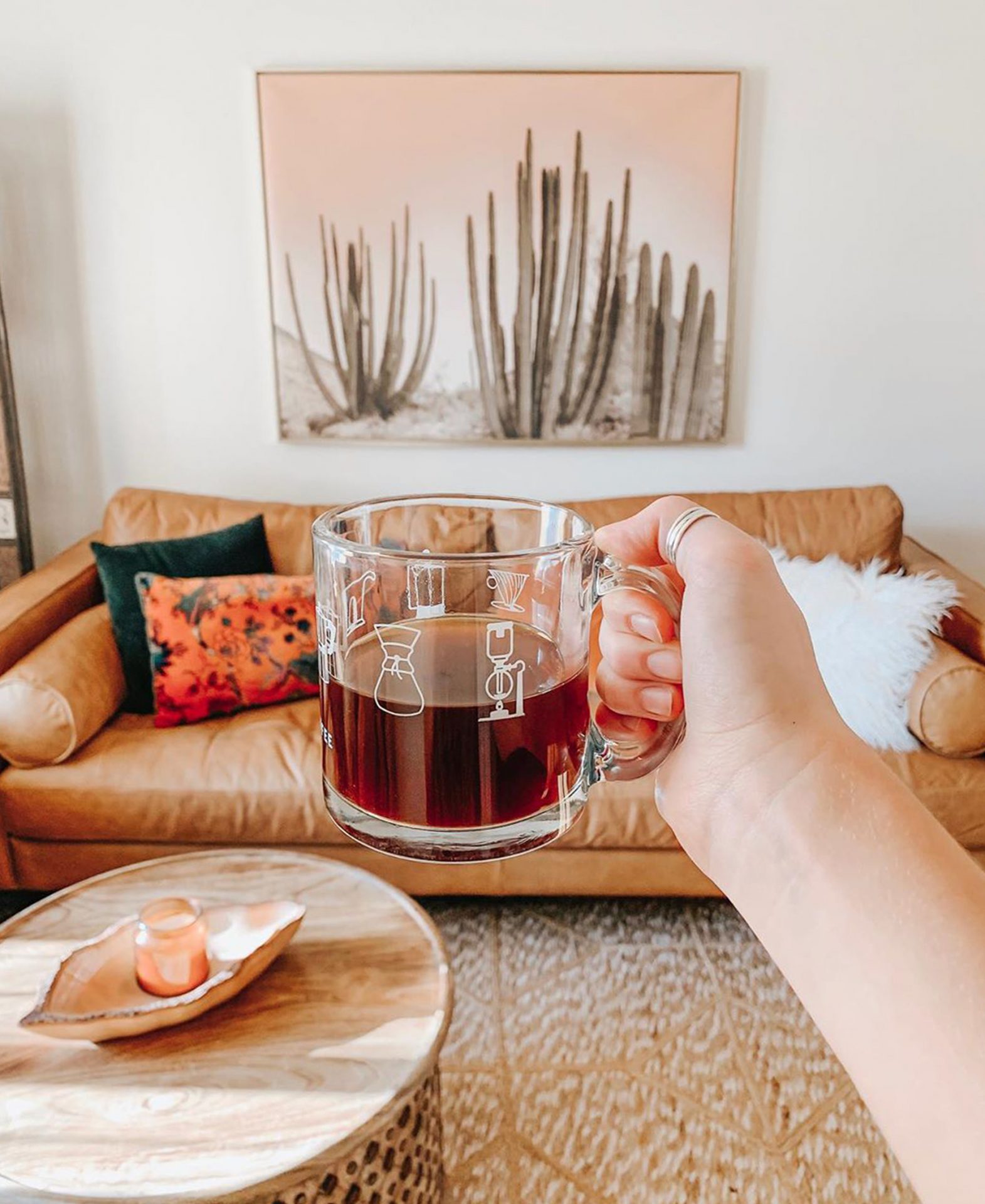 Macaela Trapp holds a cup of coffee up to her Article Sven sofa