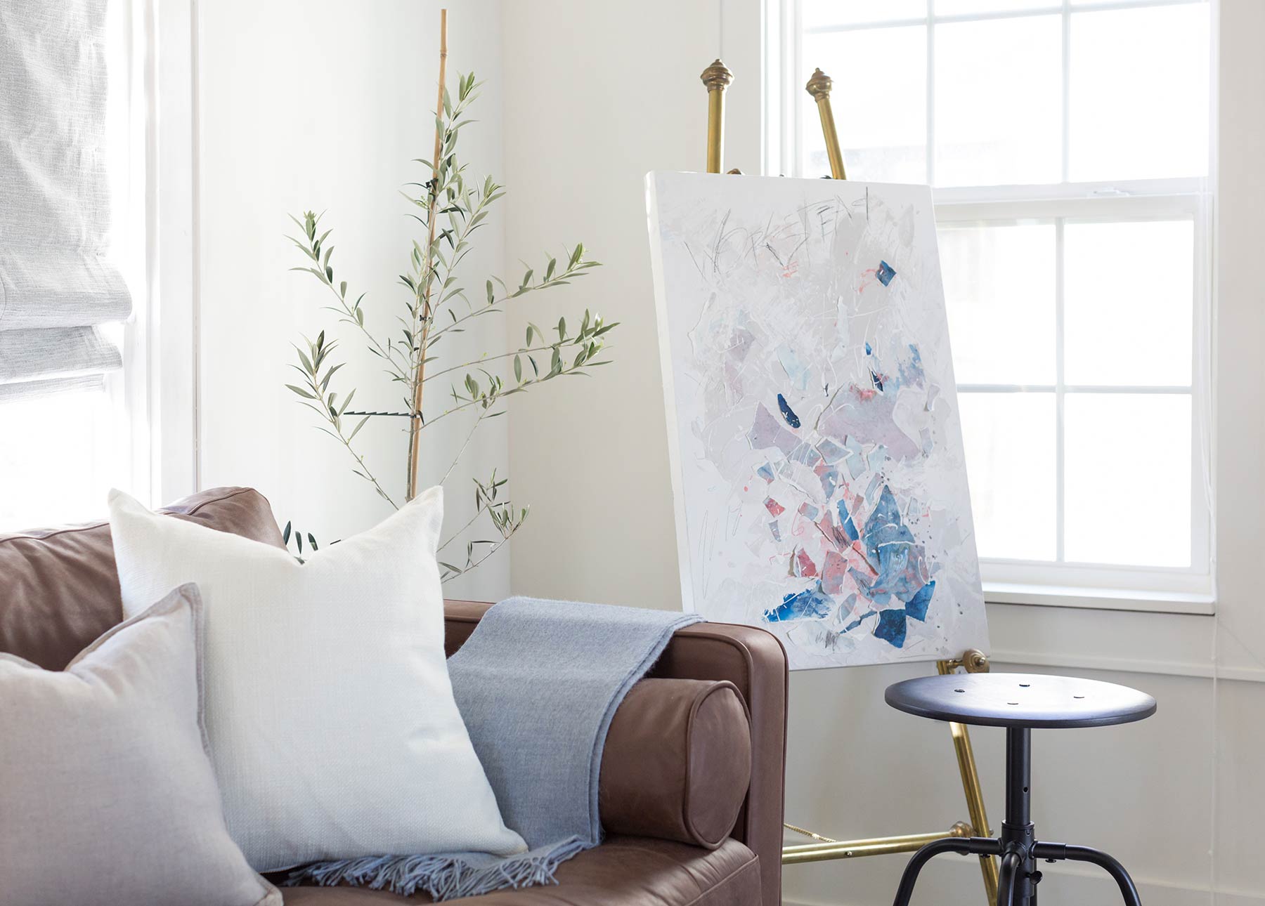 The Makerista's living room, with a Sven Chocolat sofa and artwork on an easel.