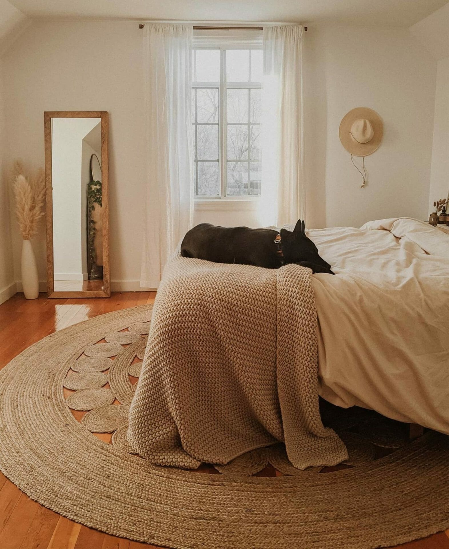Lizzy Powers dog naps on the bed while the jute Upsa Rug defines the space.