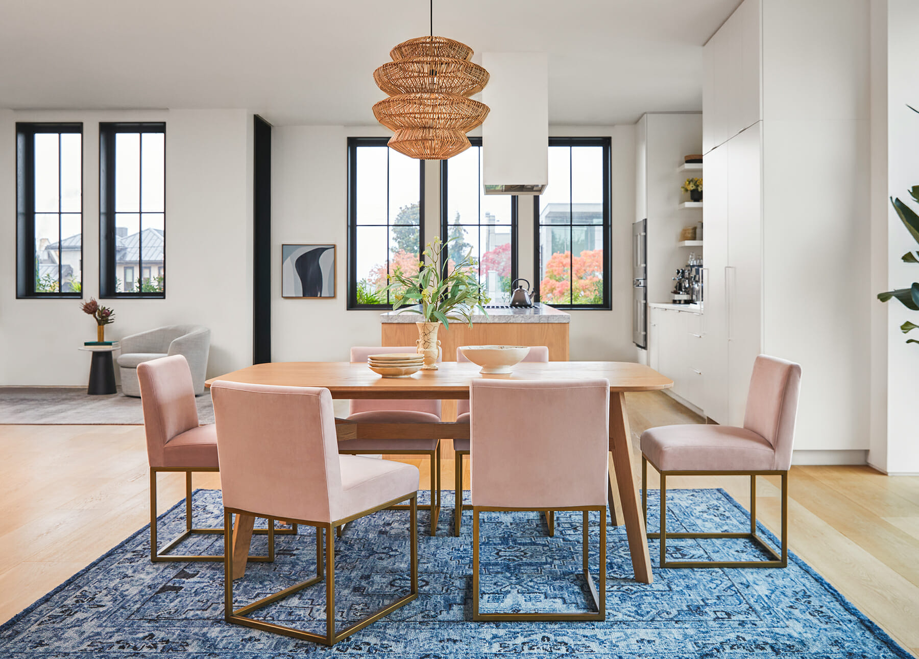 The blue Zakra Rug is shown with light pink Oscuro dining chairs.