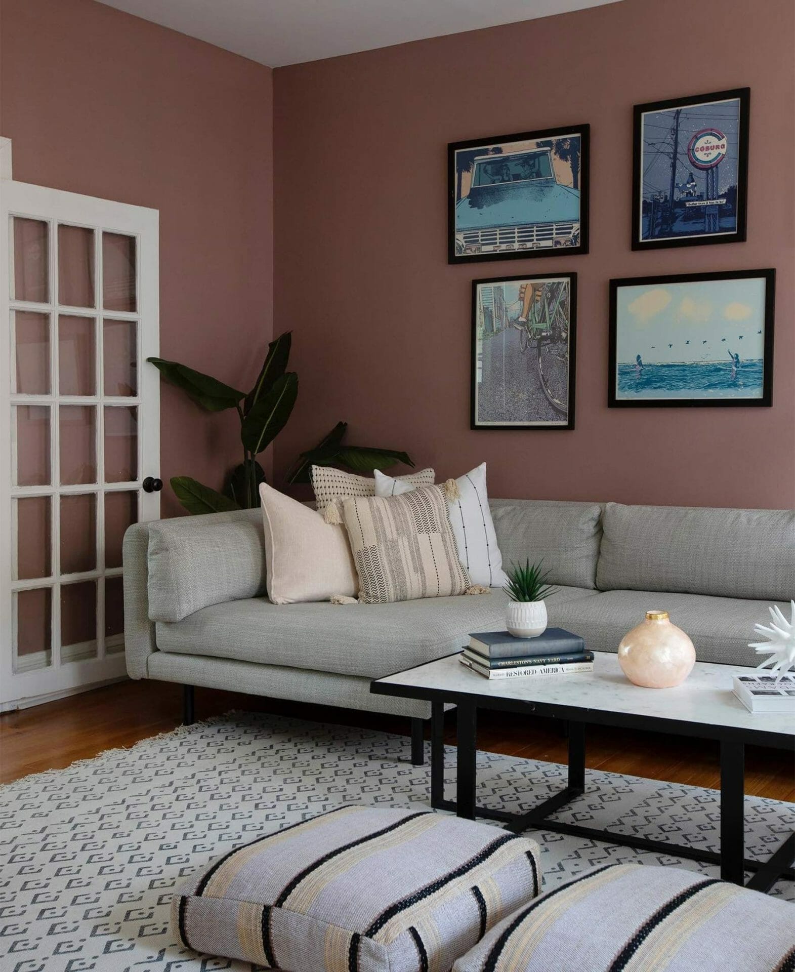 A gray Lappi Sectional from Article sits in a mauve living room in front of a gallery wall.