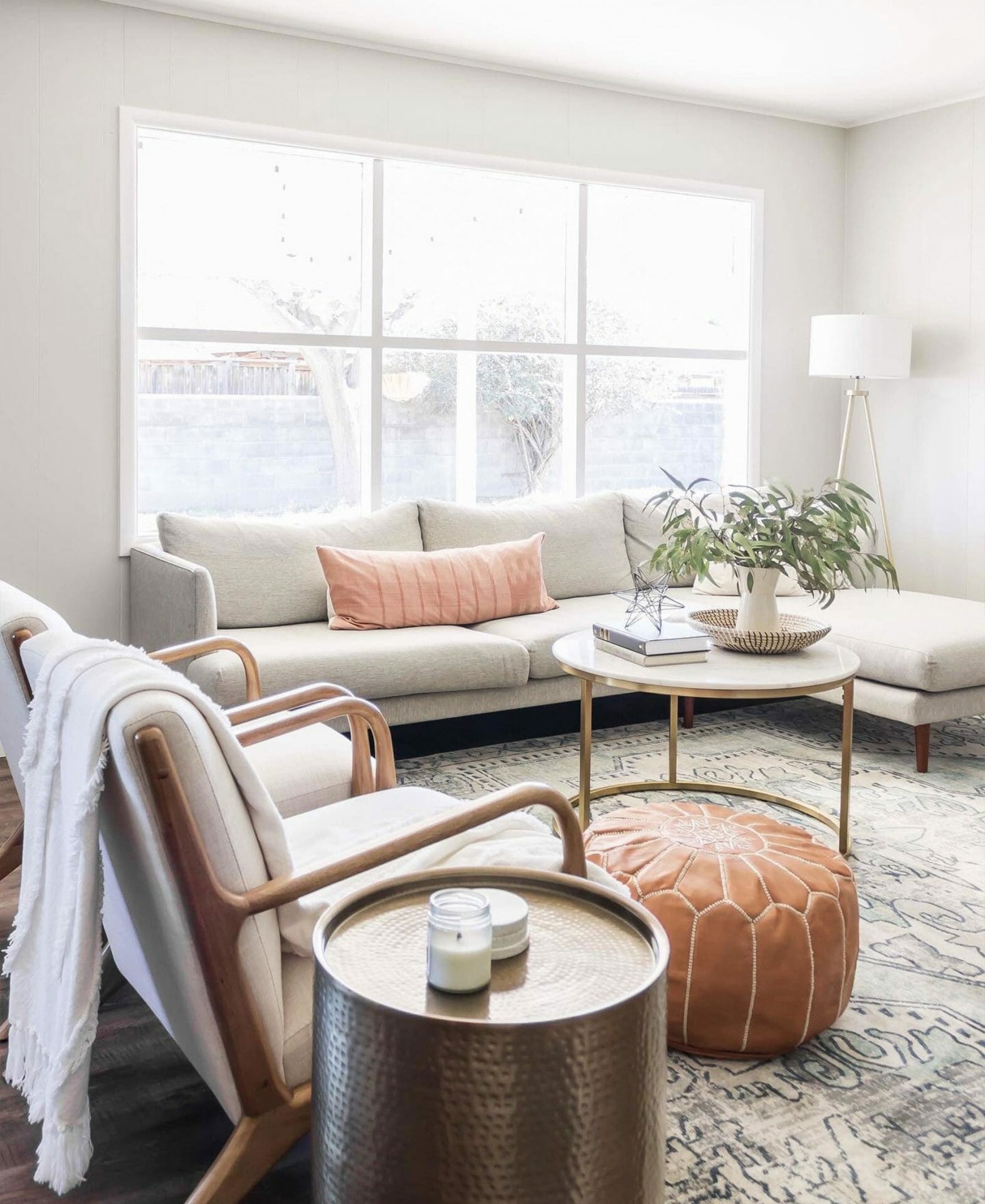 A gray sectional sofa sits in front of a large window in this bright space.