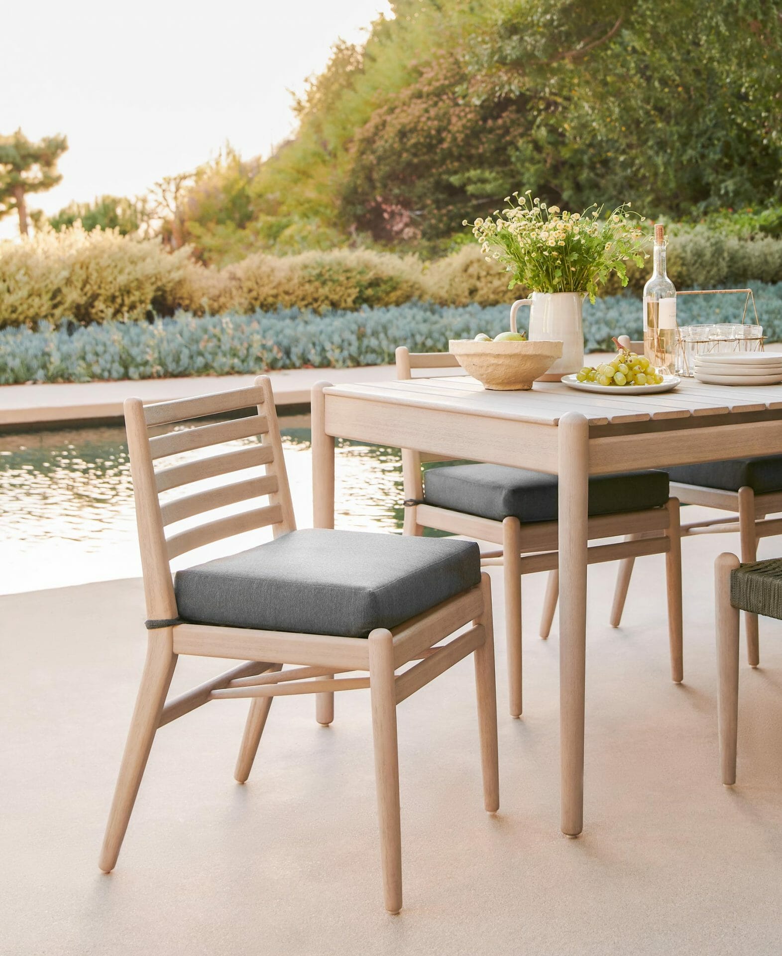 The Lagora Dining Table and Chairs are seen poolside.