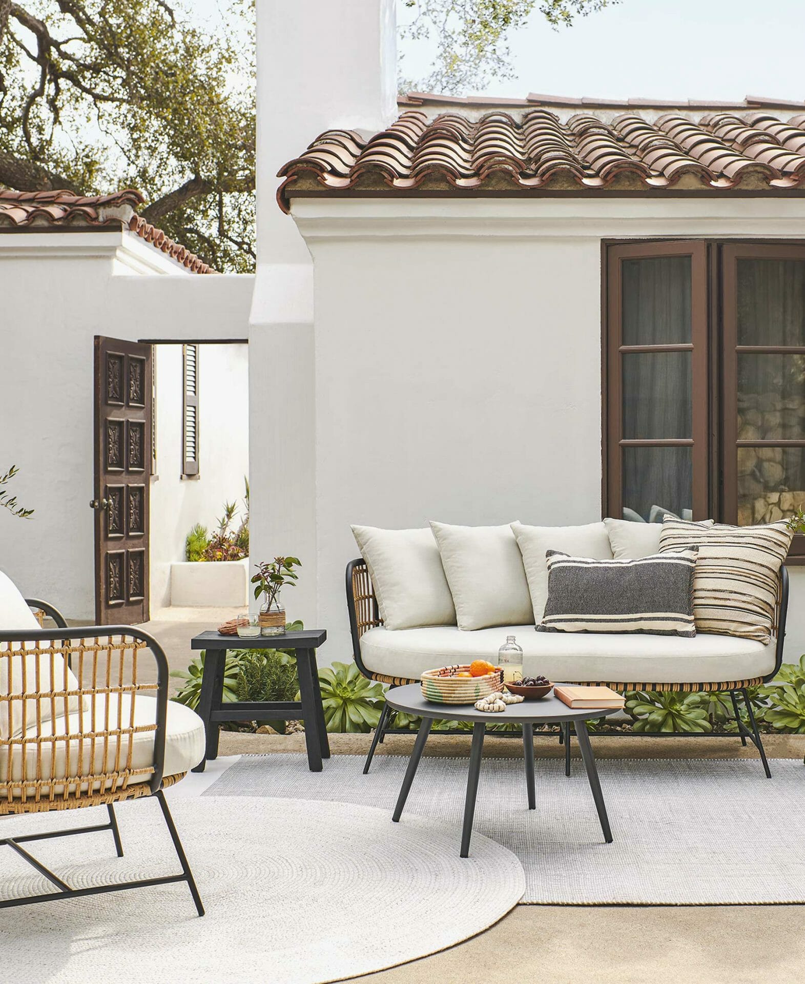 The Onya Sofa is featured in a condo courtyard with Spanish-style architecture.