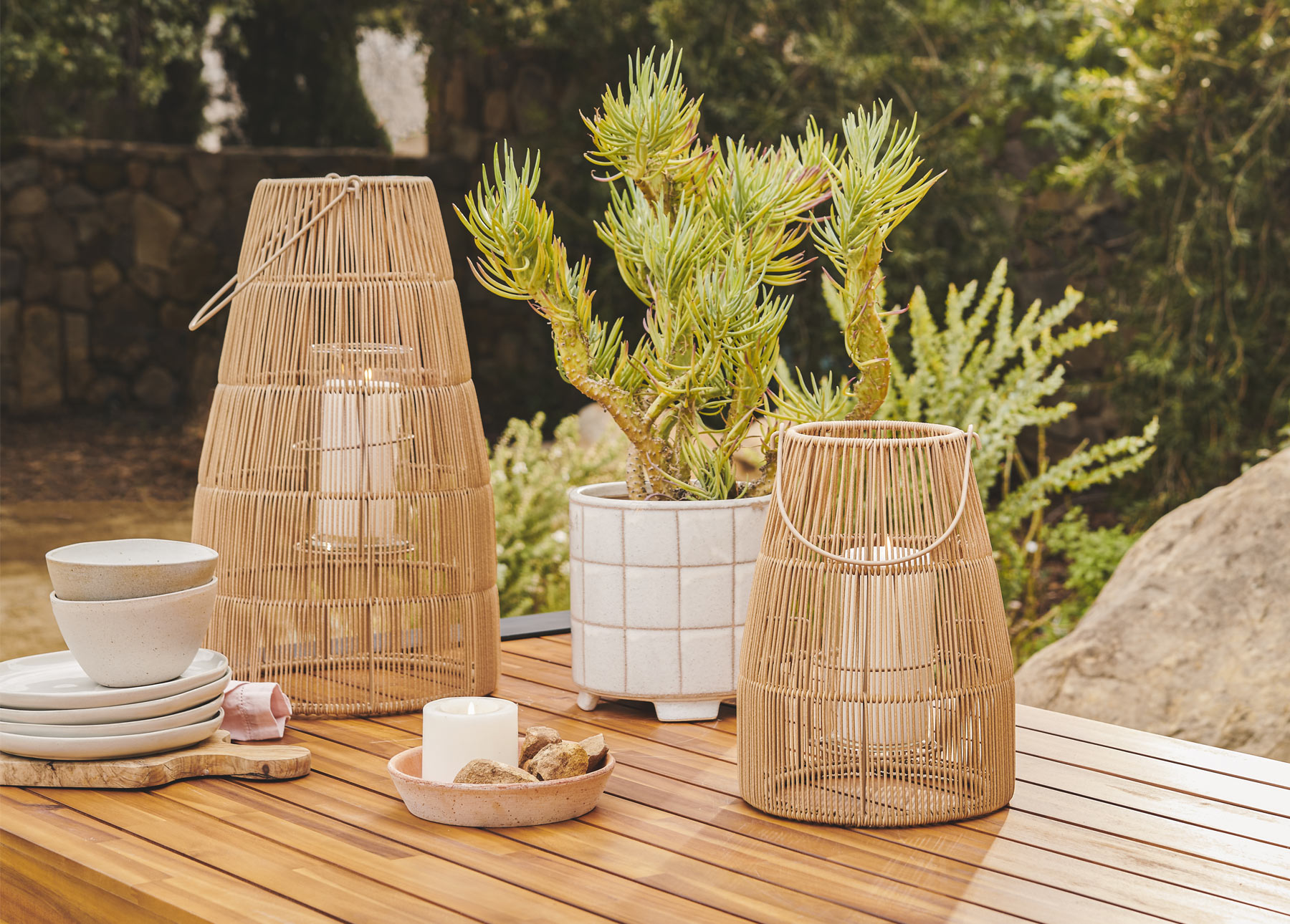 Two Vezda Lanterns are shown with a potted cacti in the background.